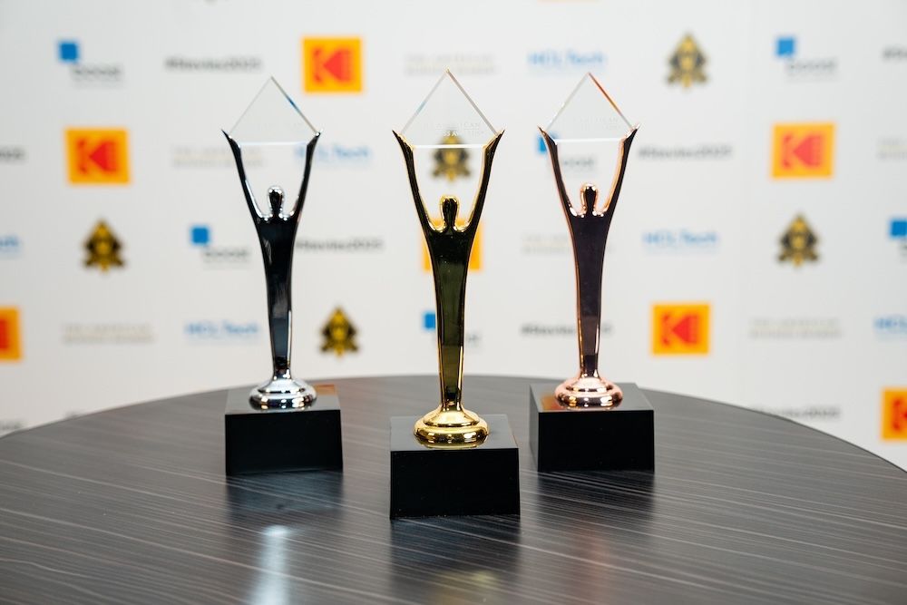 Bronze, Gold and Silver Stevie Award trophies on black bases, each a figure with arms raised holding a crystal diamond